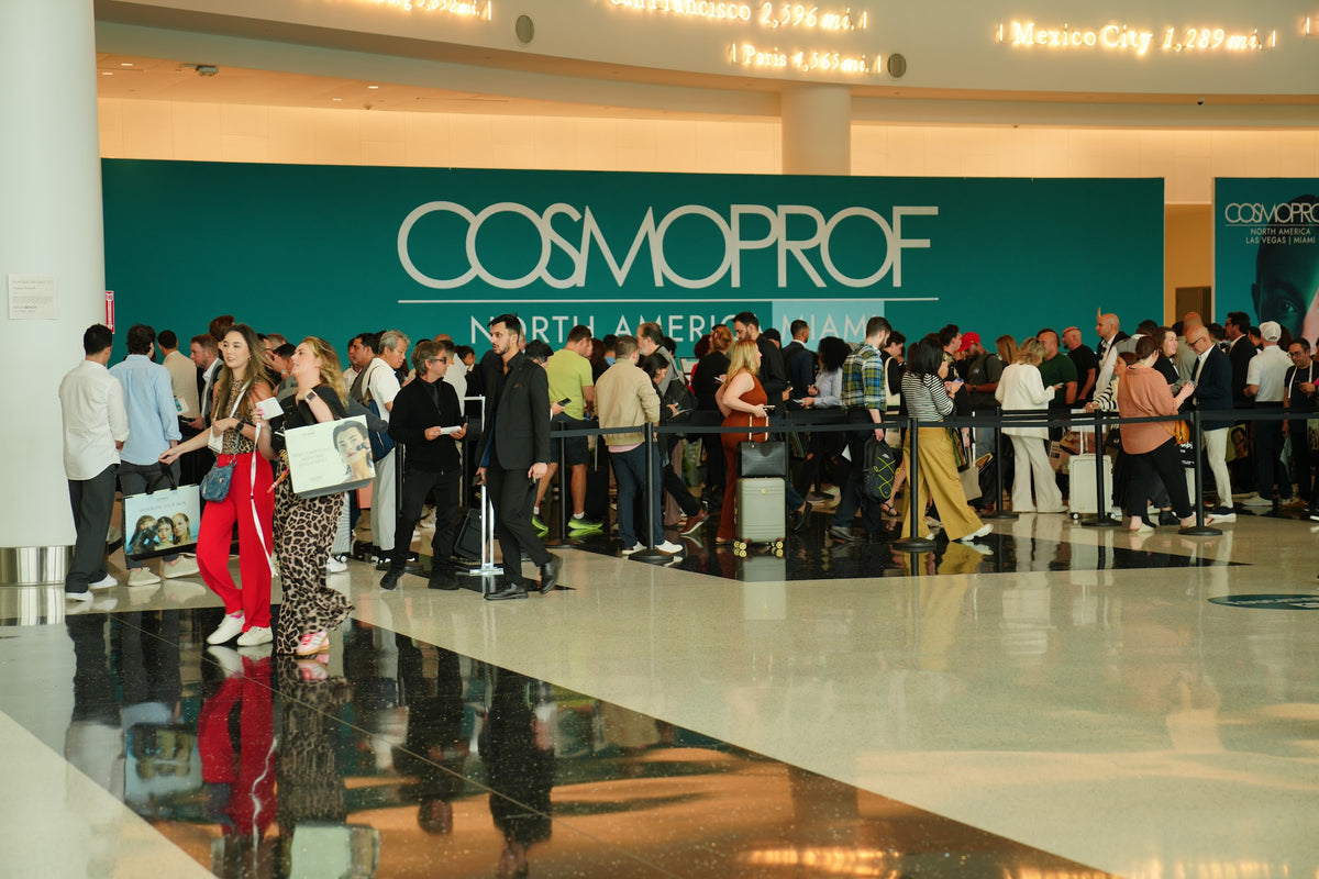 Visitors in the entrance hall of Cosmoprof North America Miami, under the Cosmoprof sign